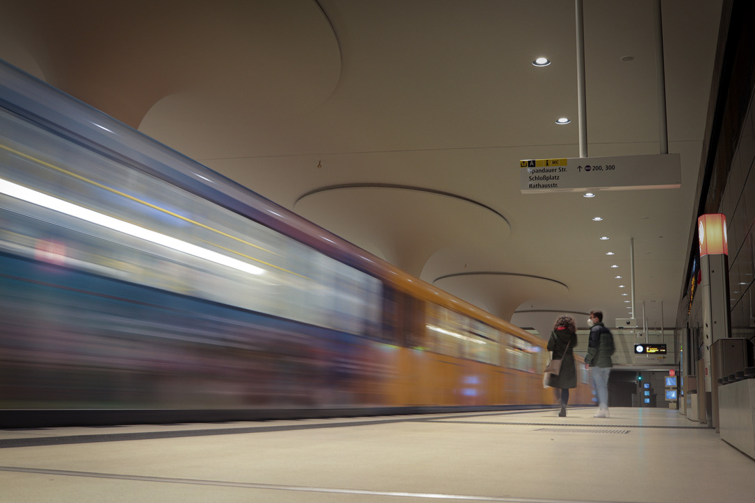 A streak of compressed light passing through concrete architectures.